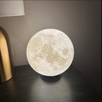 Moon lamp on a dark surface with a neutral background