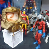 Collection of action figures with a prominent gold helmeted figure in the foreground.